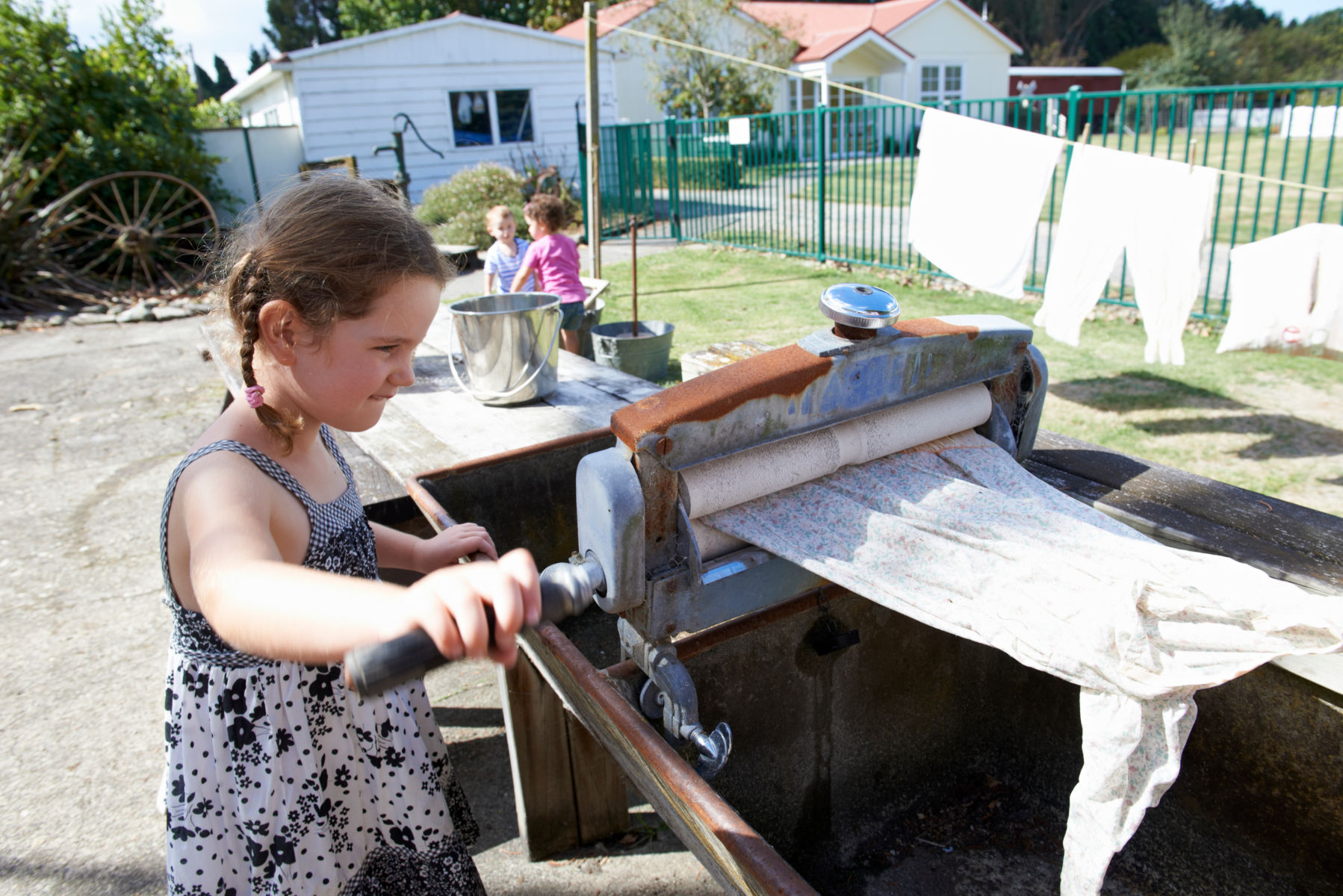 Girl operating a laundry straining roller